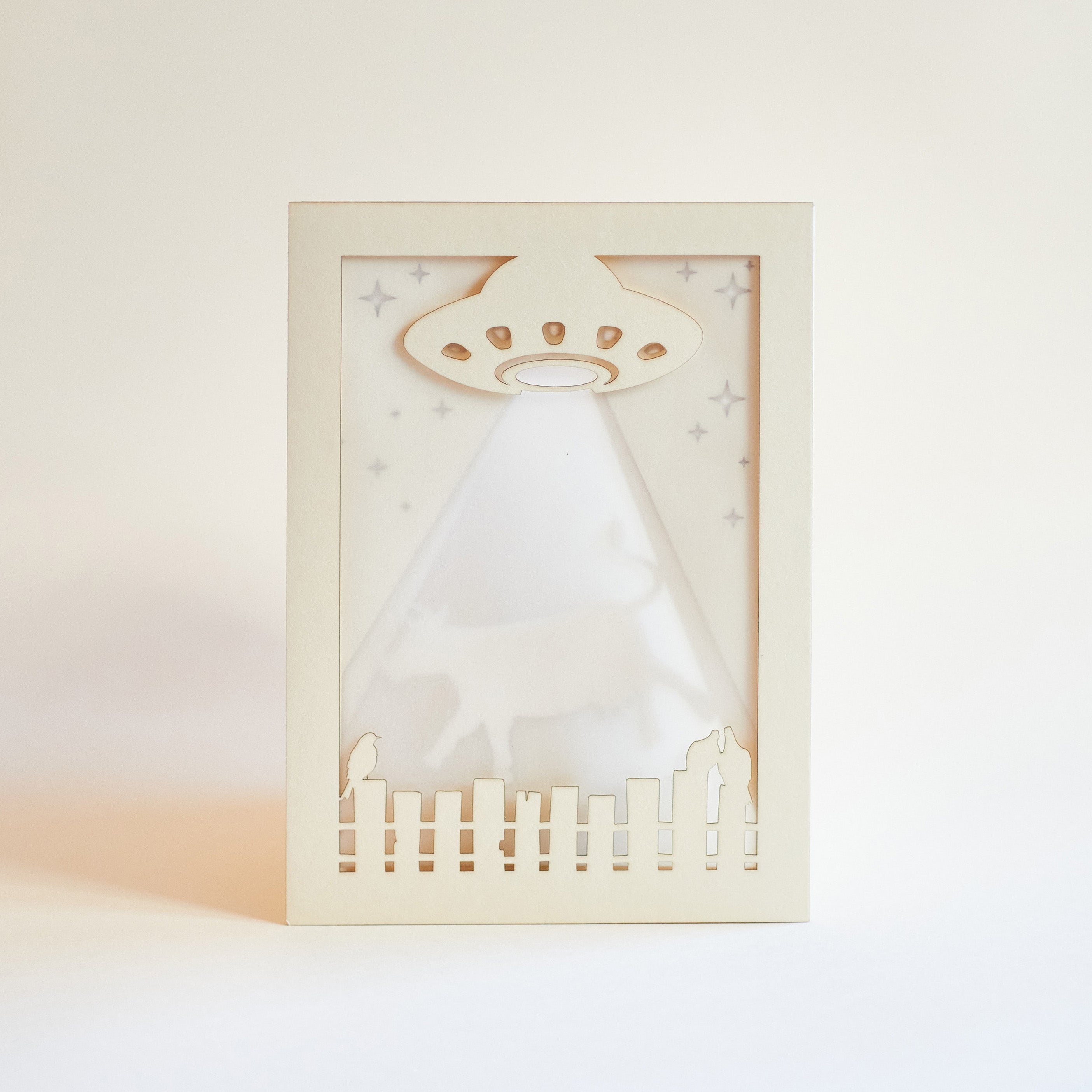 Decorative wall art with a UFO design on a white background