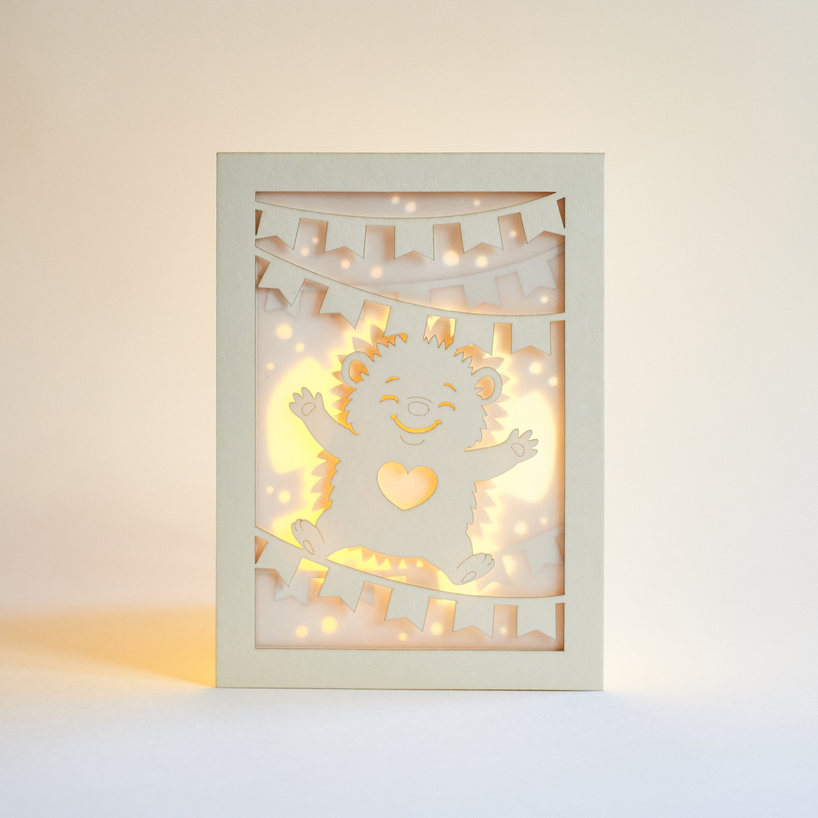 Cute hedgehog making snow angel with festive banner flags