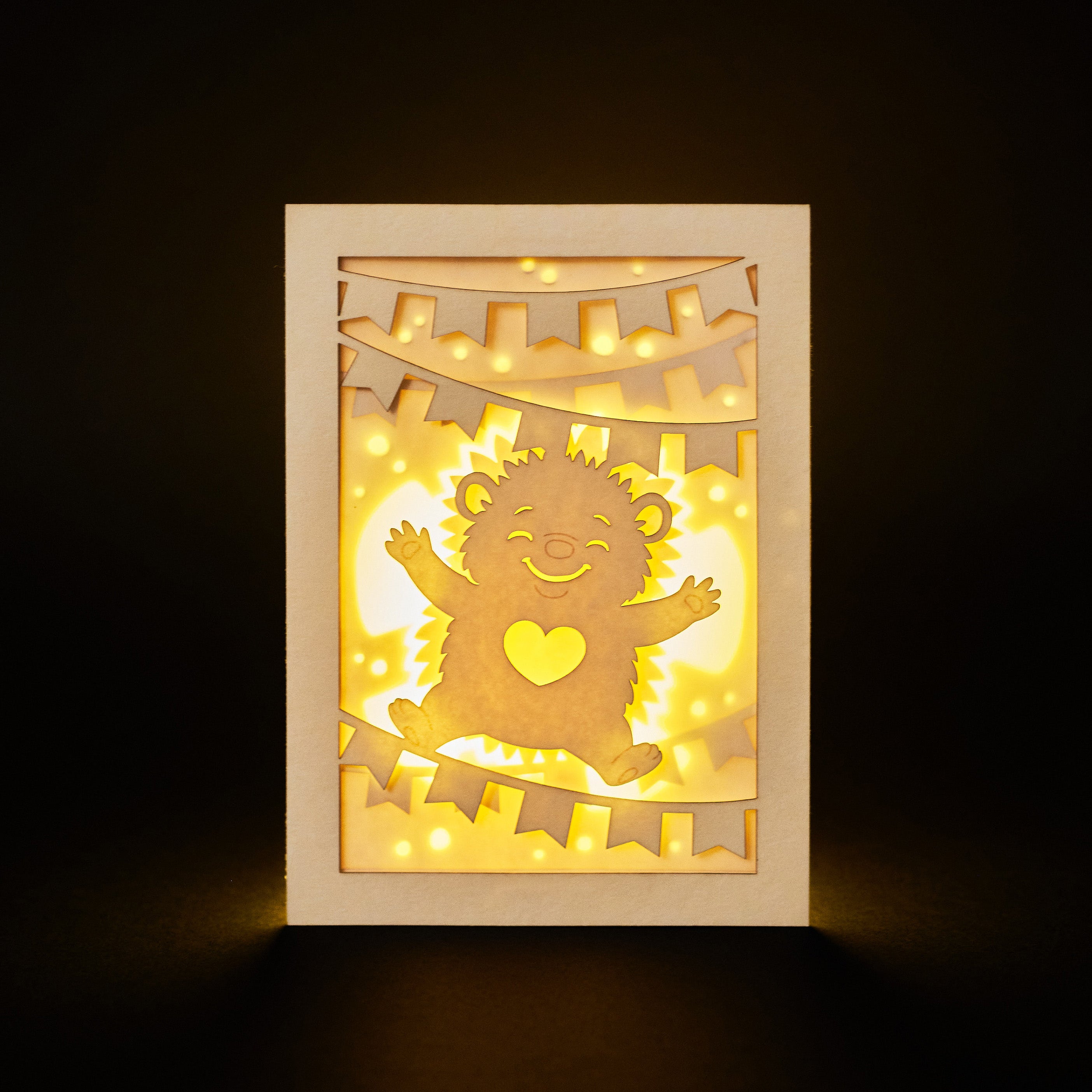 Cute hedgehog making snow angel with festive banner flags