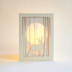 Graceful deer silhouette in winter forest with moon