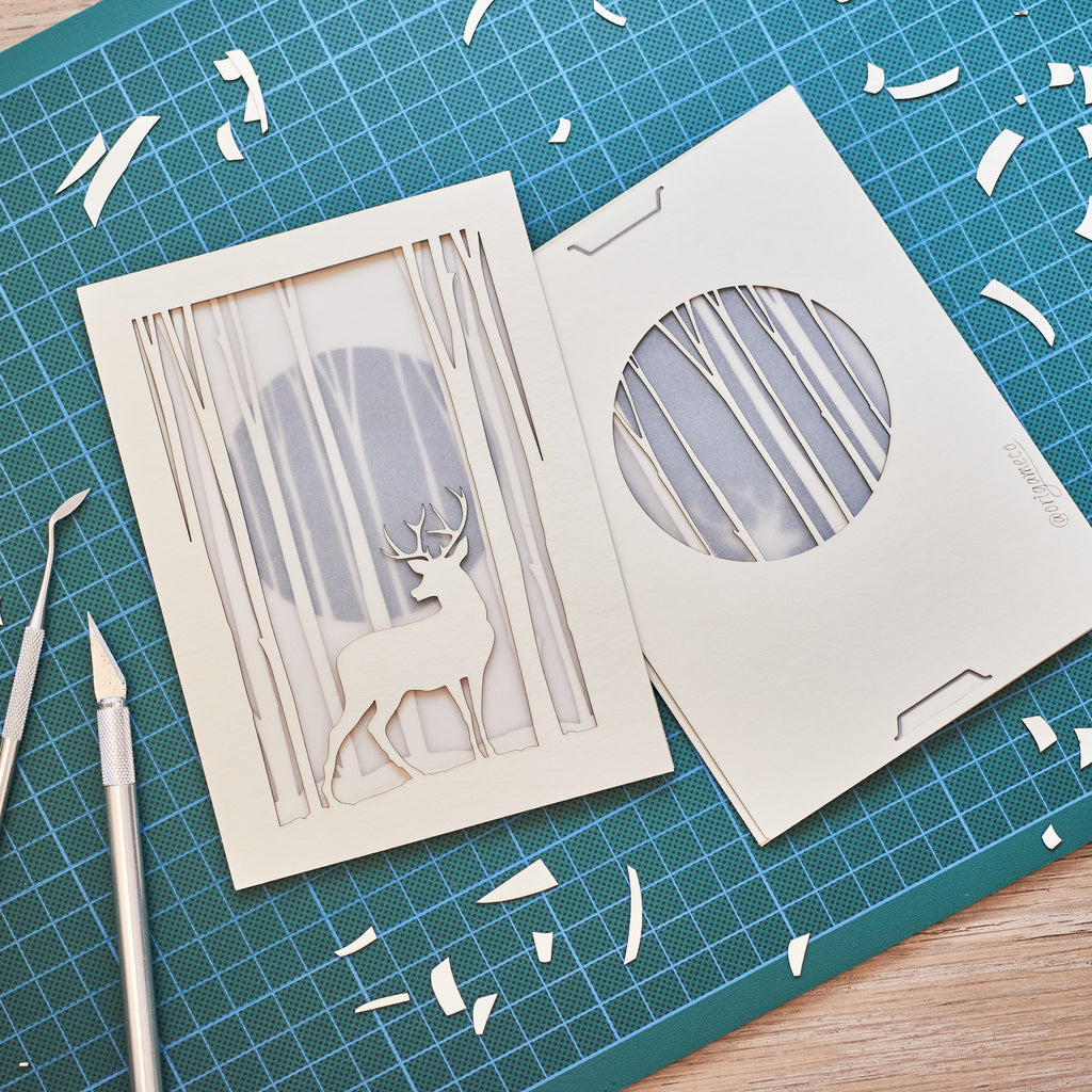 Graceful deer silhouette in winter forest with moon