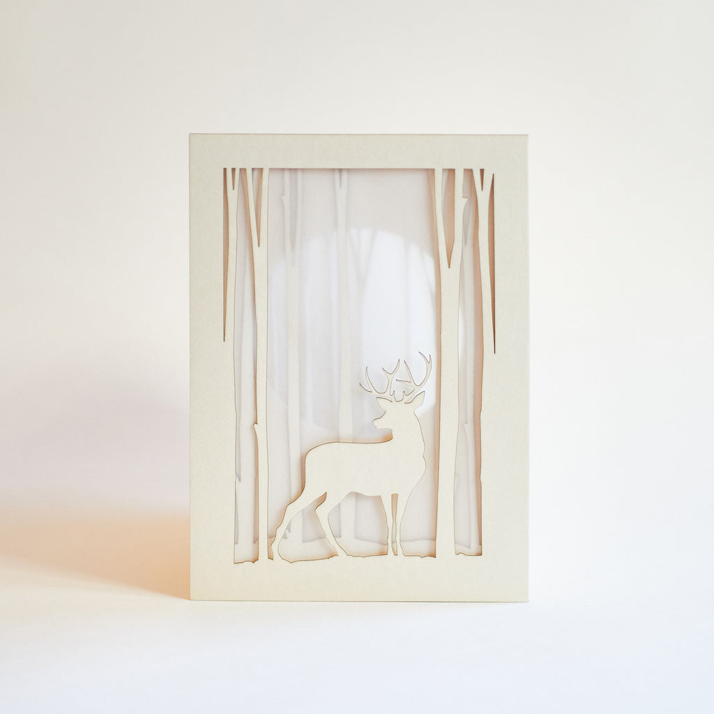 Graceful deer silhouette in winter forest with moon