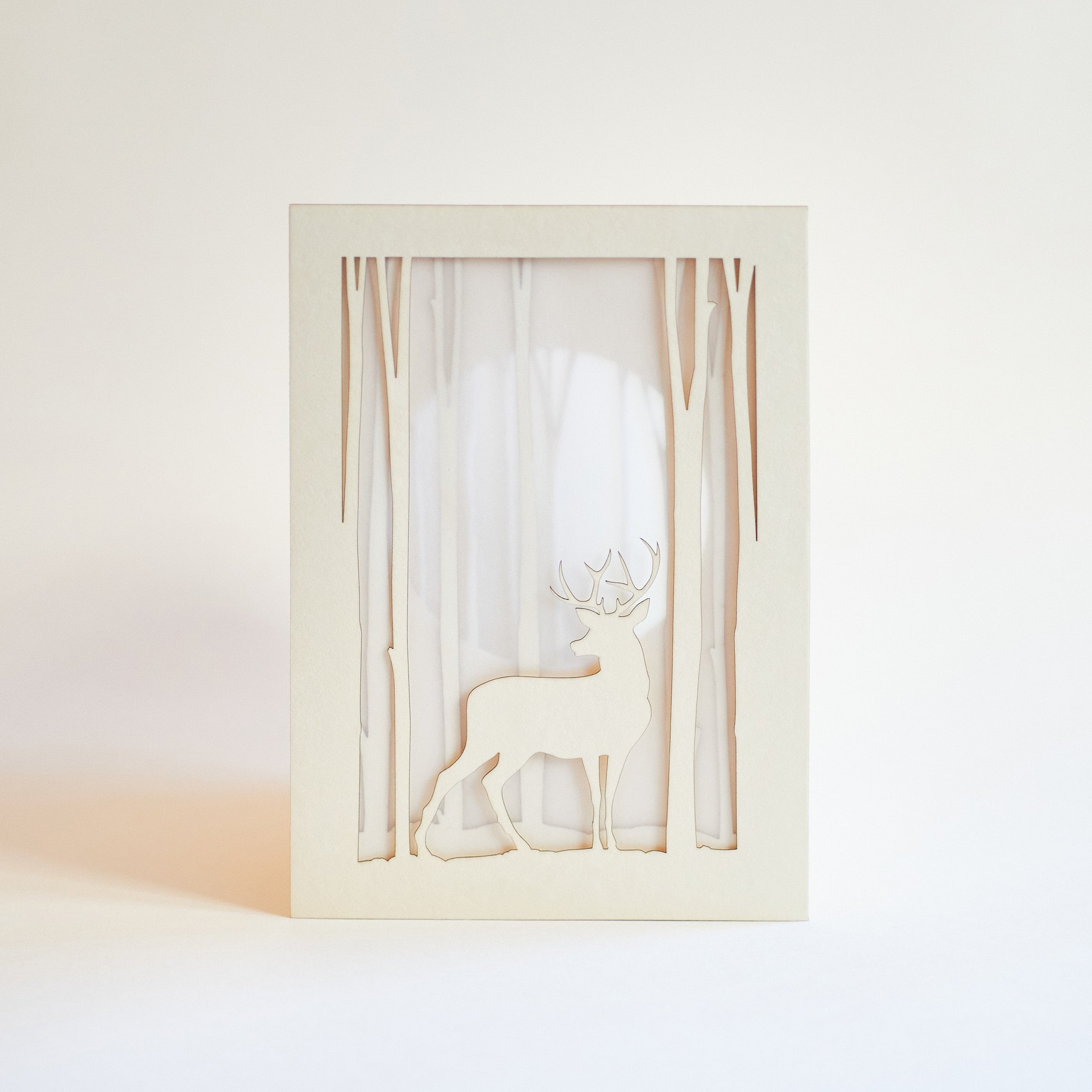 Graceful deer silhouette in winter forest with moon