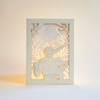 Zagreus from Hades game with sword standing in front of olive branches and flames