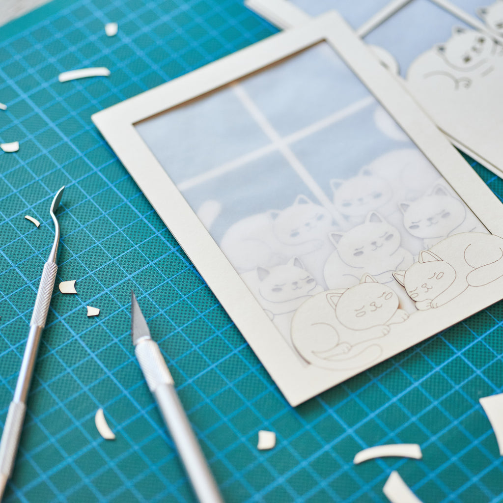 Cats basking on sunny windowsill with closed eyes and tails up