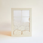 Cats basking on sunny windowsill with closed eyes and tails up