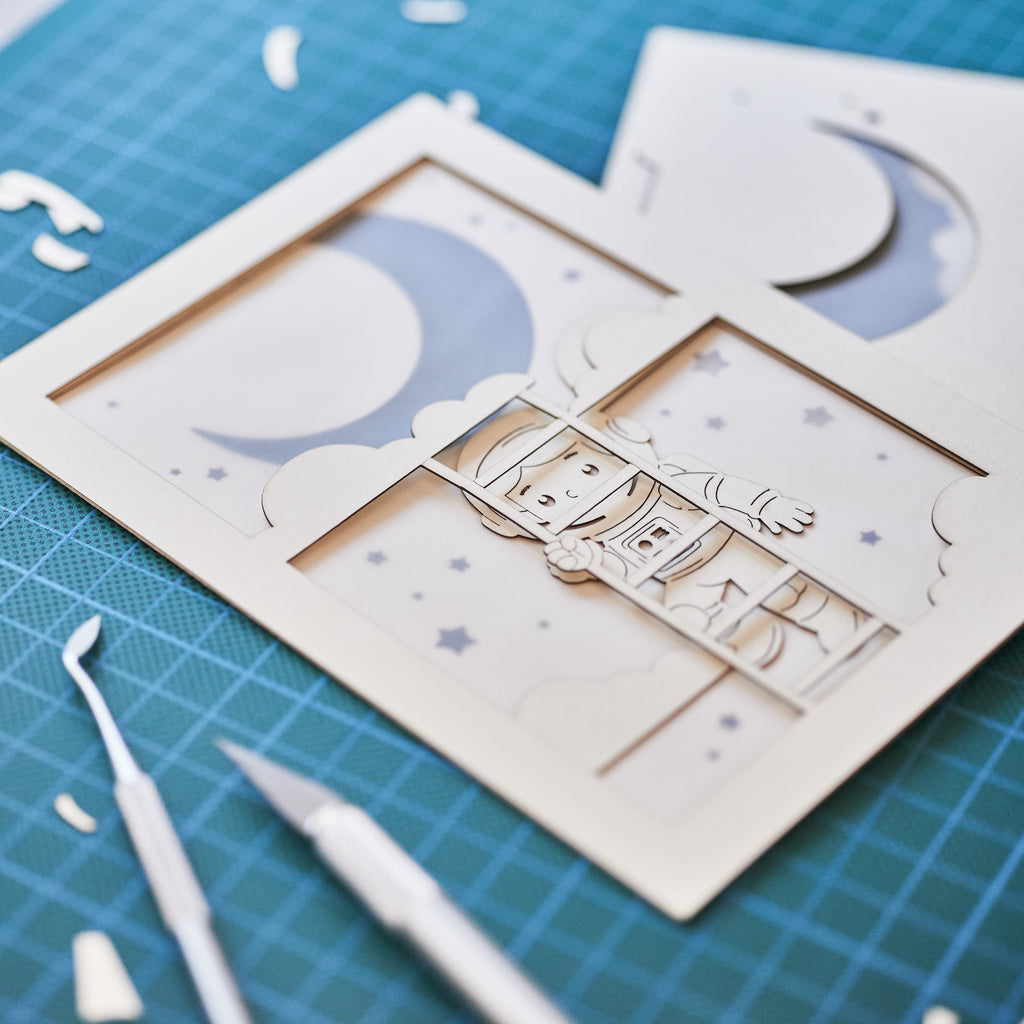 Little boy astronaut climbing ladder to moon and stars