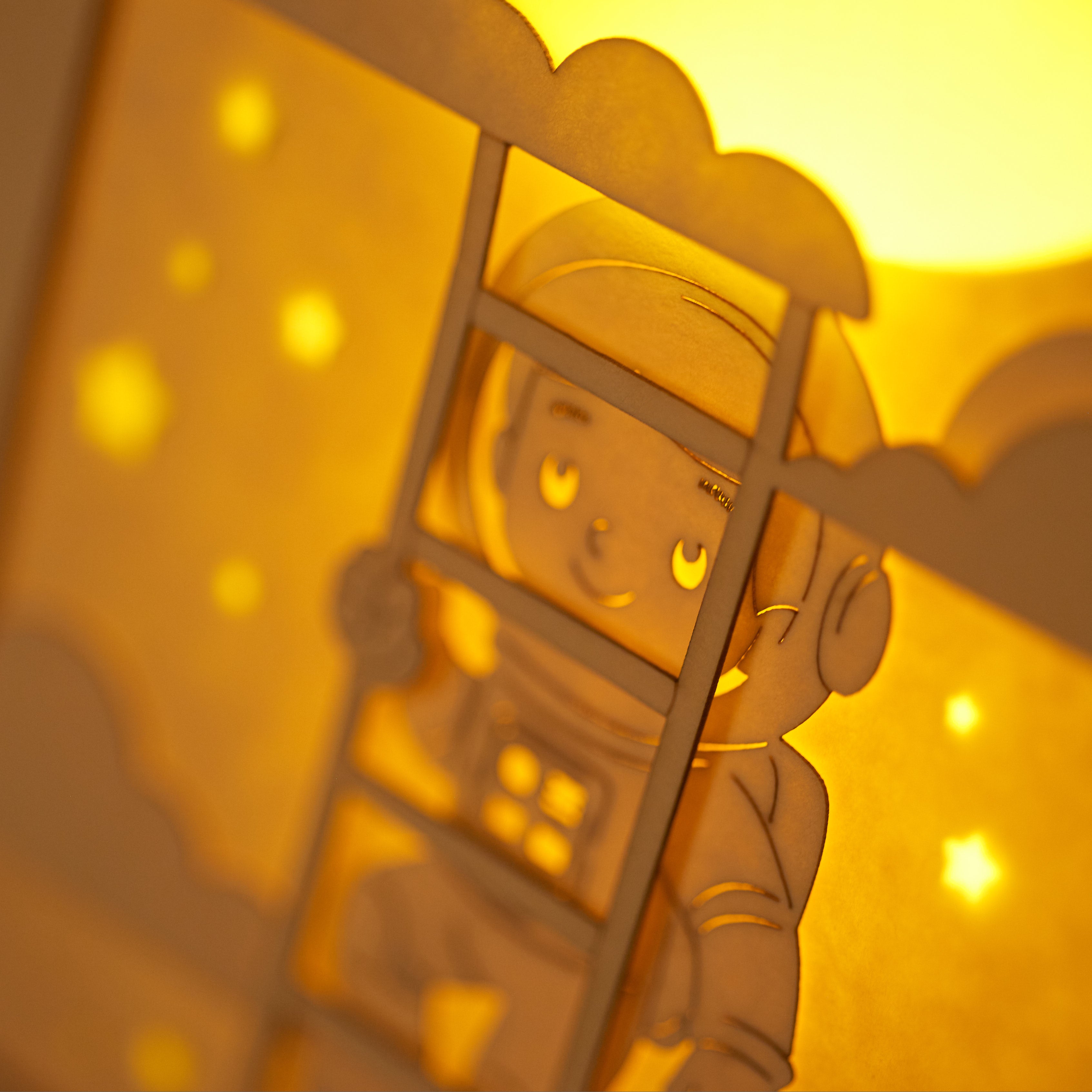 Little boy astronaut climbing ladder to moon and stars