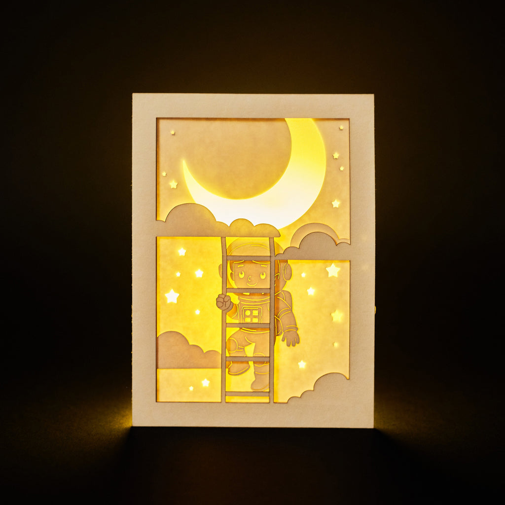 Little boy astronaut climbing ladder to moon and stars