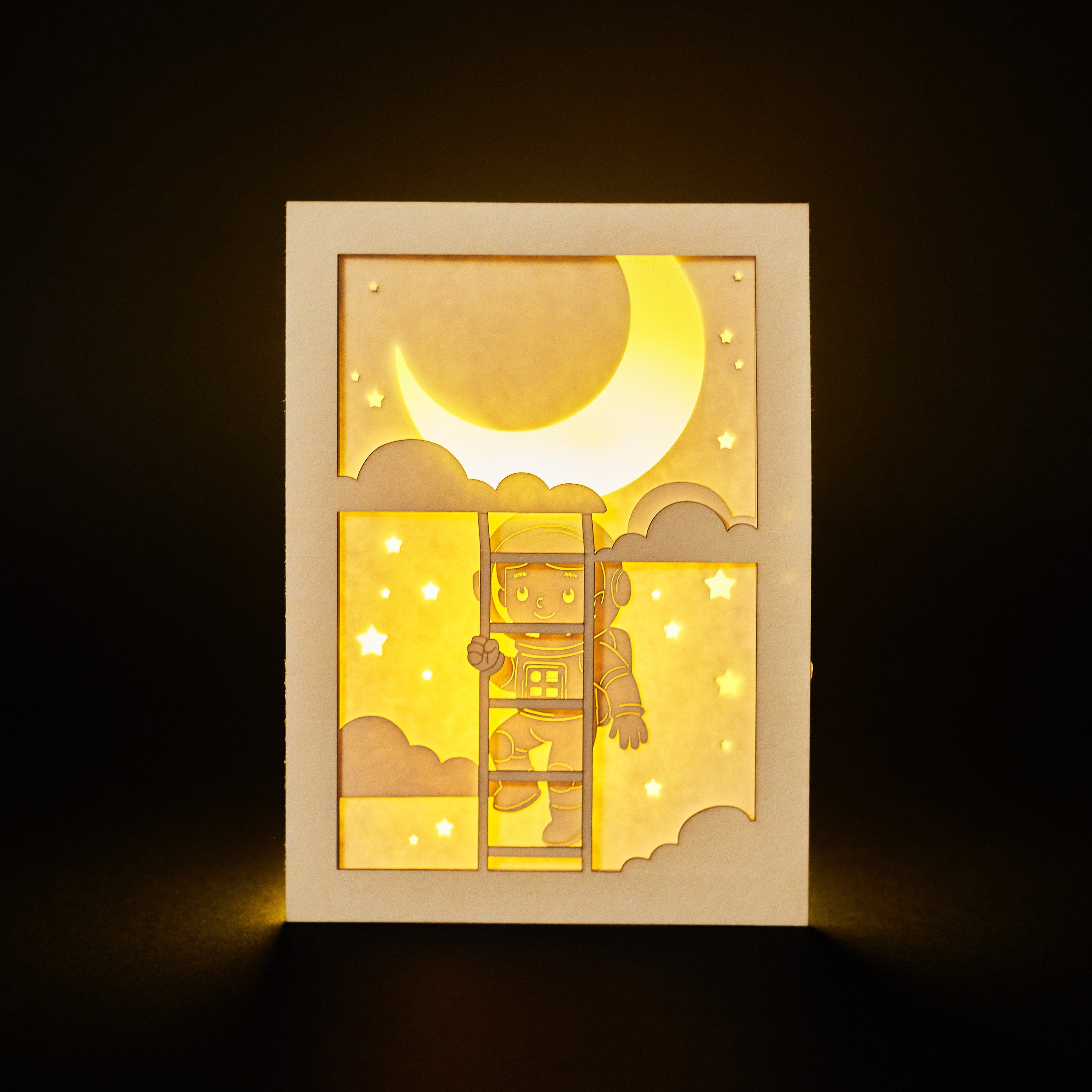 Little boy astronaut climbing ladder to moon and stars