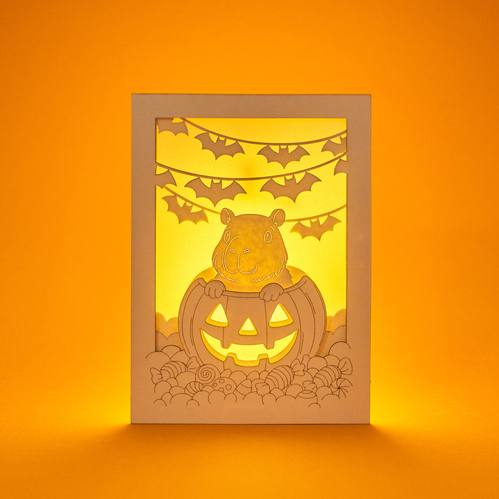 Cute capybara in jack-o-lantern with candy and bats Halloween