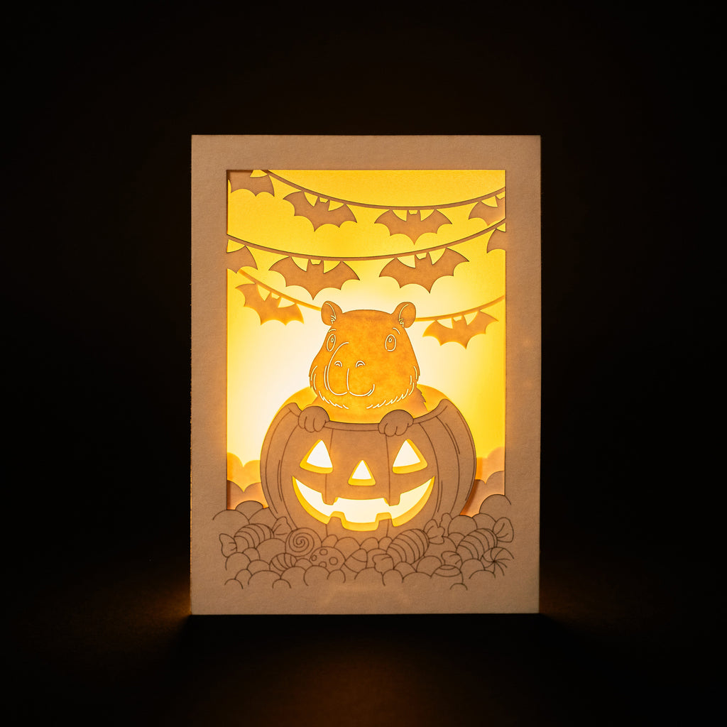 Cute capybara in jack-o-lantern with candy and bats Halloween