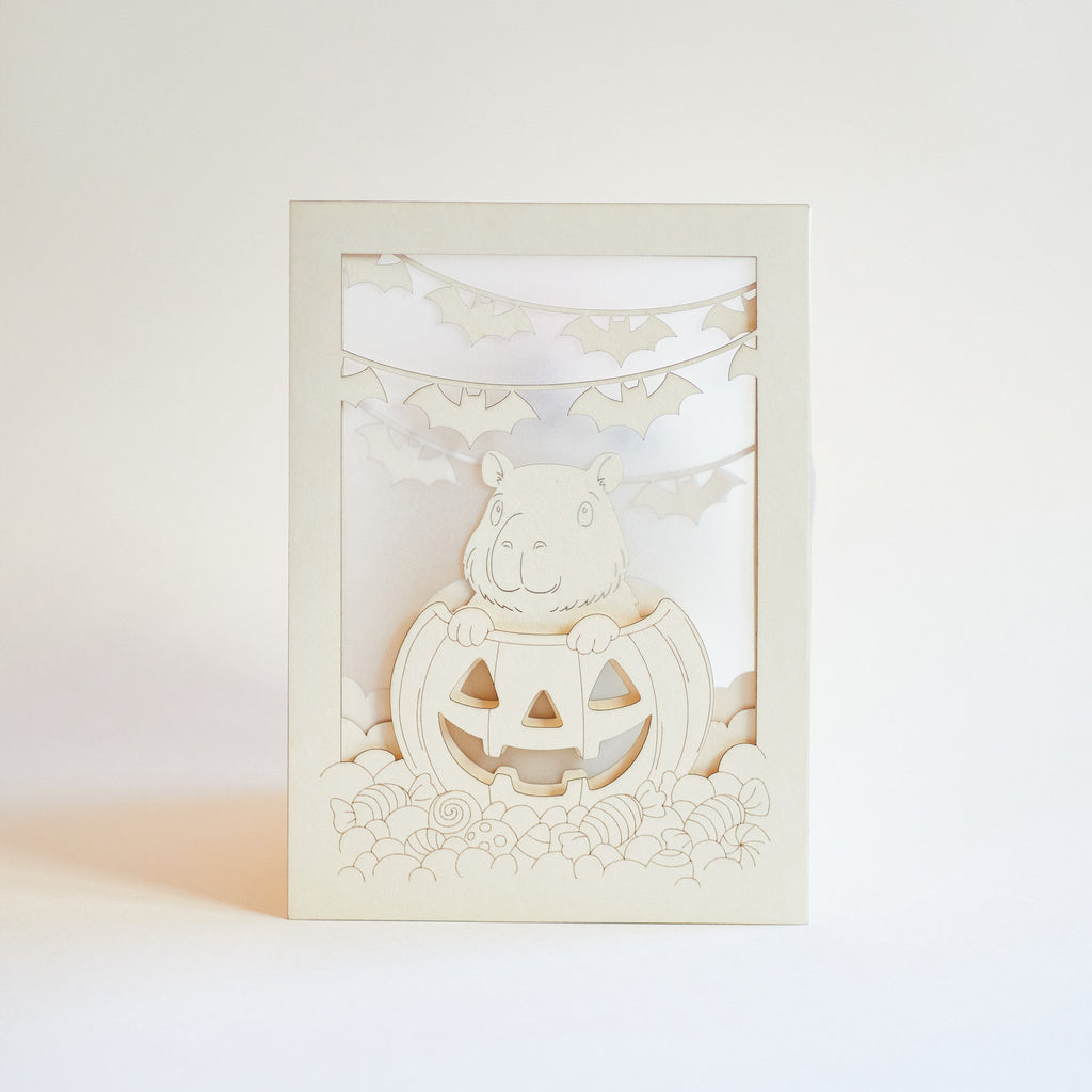 Cute capybara in jack-o-lantern with candy and bats Halloween