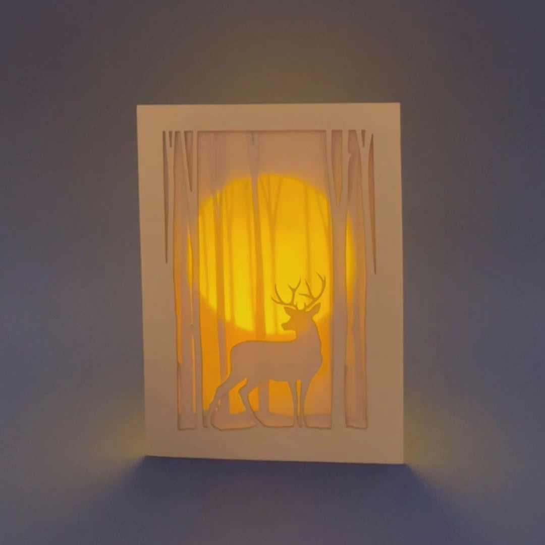 Graceful deer silhouette in winter forest with moon