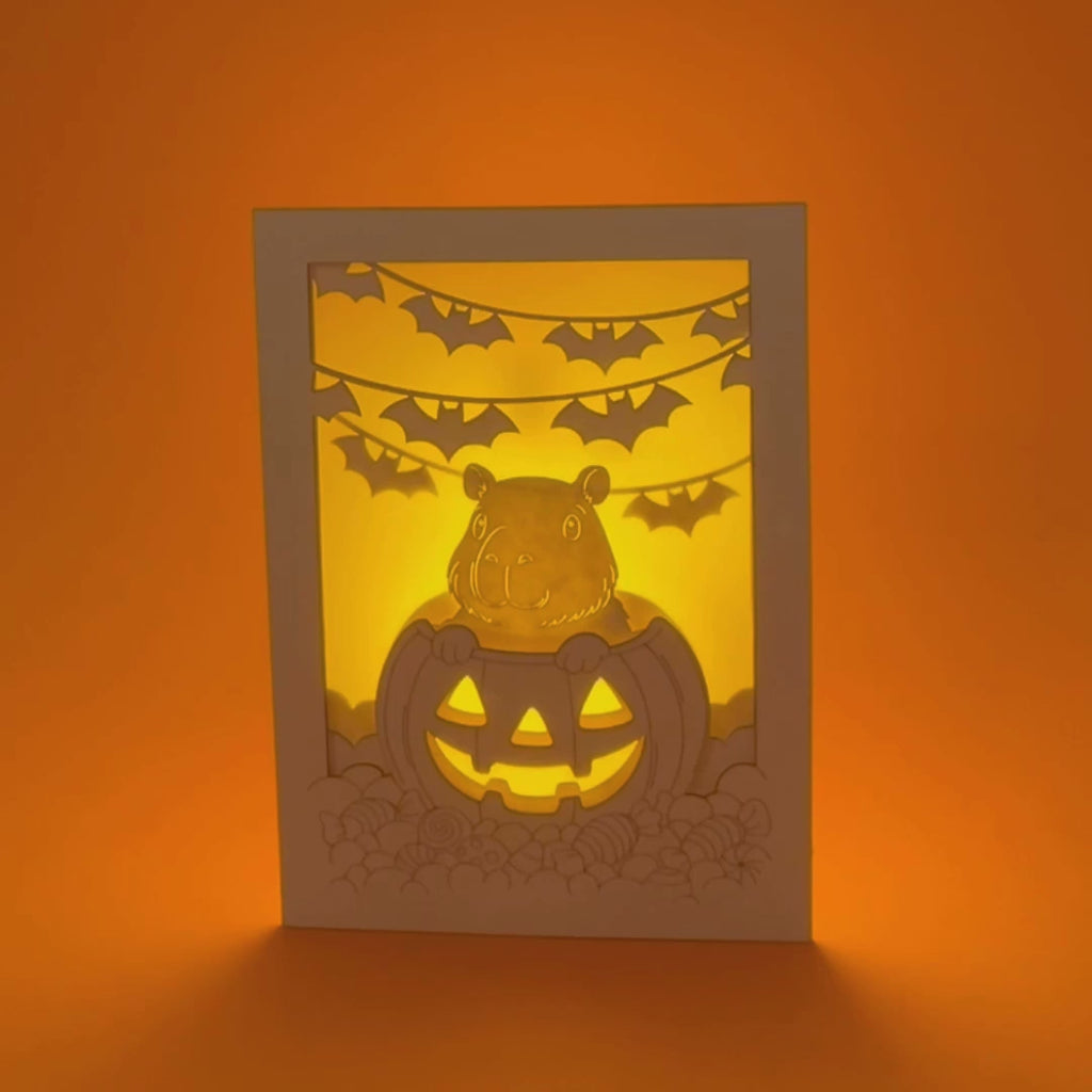 Cute capybara in jack-o-lantern with candy and bats Halloween